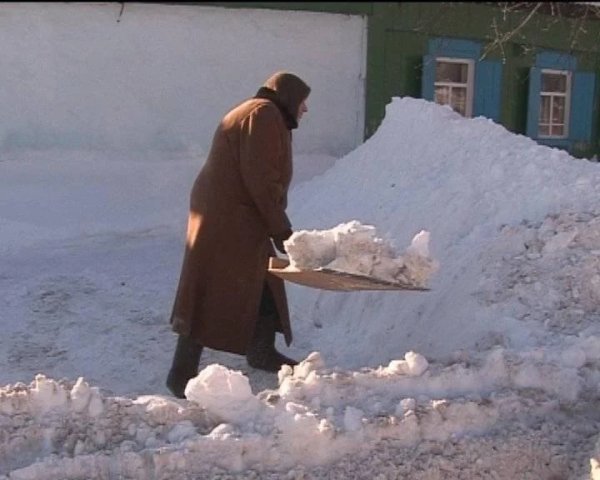Бабушка убирает снег