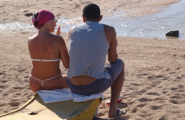 Мужчина загорает в стрингах