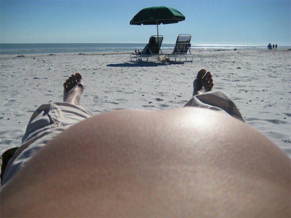 С большим пузом на пляже