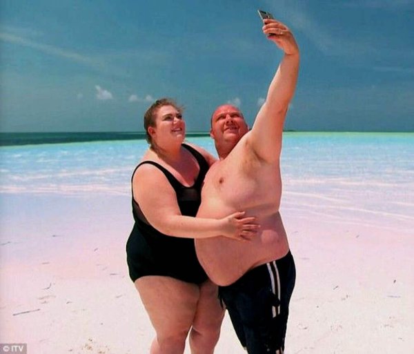 Полные люди на пляже