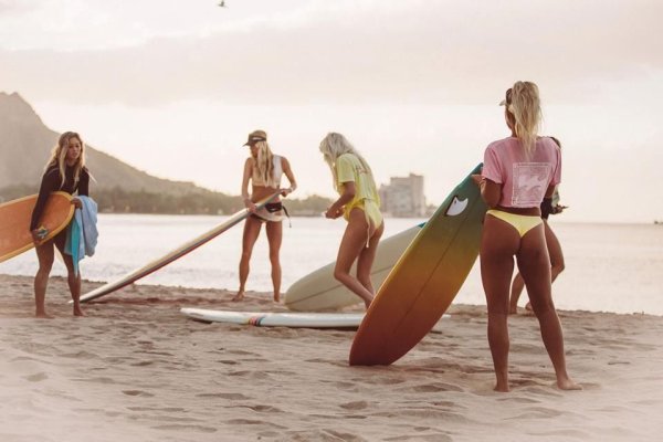 Девушка на пляже с доской для серфинга