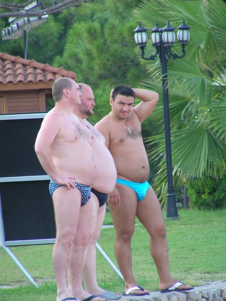 Полные мужчины на пляже