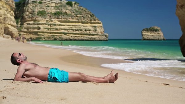 Человек лежит на пляже