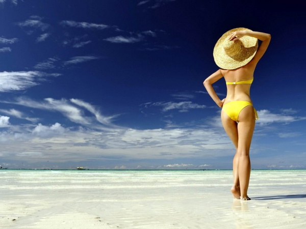 Женщина в купальнике и в шляпе