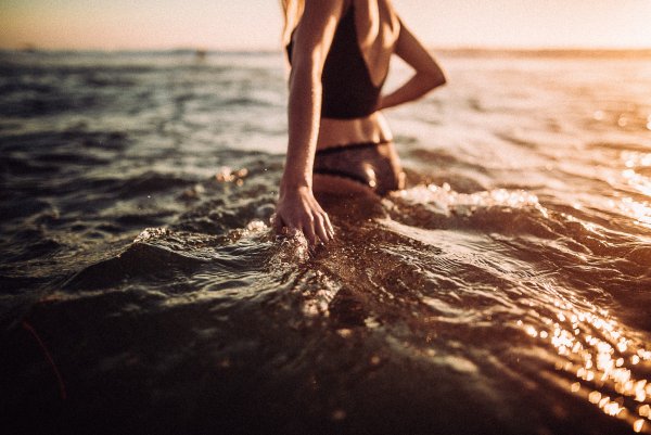 Девушка в воде со спины