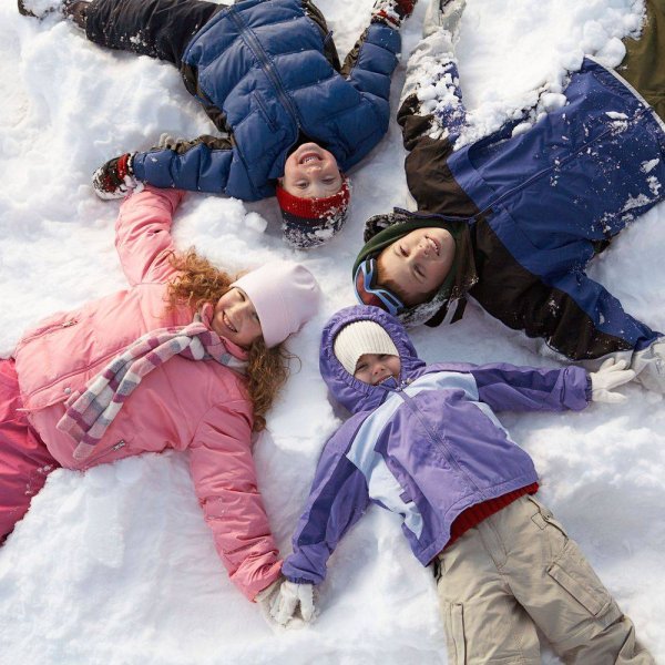 Семья делает снежных ангелов