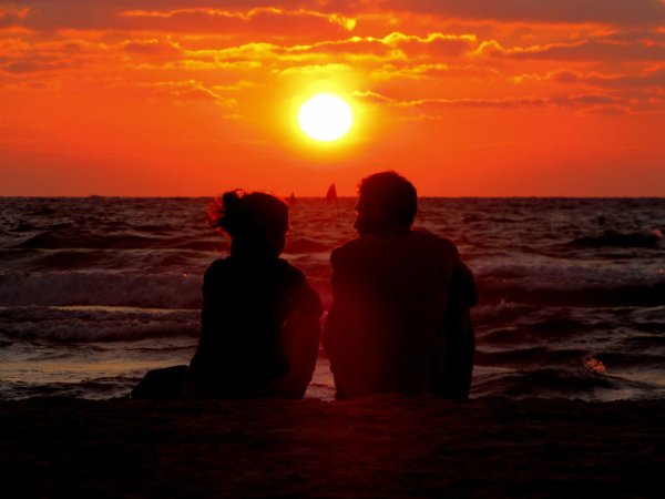 Пара на берегу моря на закате