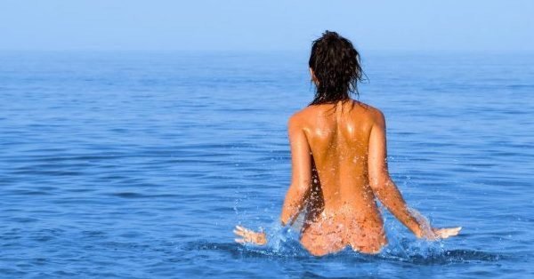 Девушка купается в море