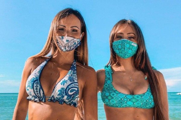 Девушка в медицинской маске на пляже