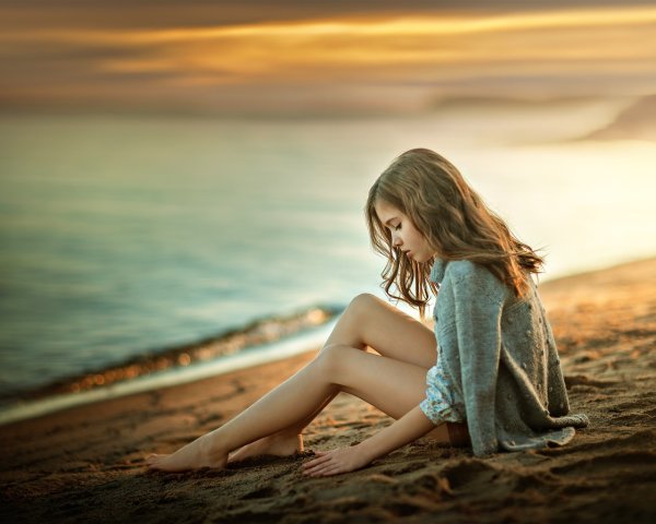 Девушка сидит на берегу