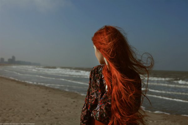 Рыжеволосая девушка на море