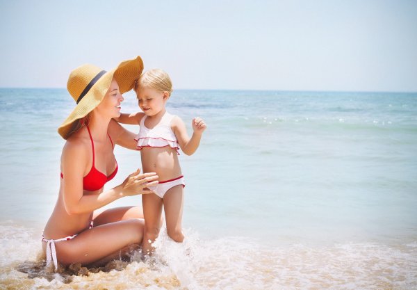 Красивая девочка с мамой на пляже