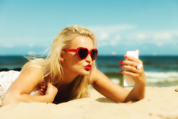 Девушка на пляже с телефоном