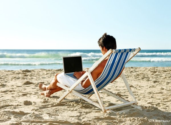 Человек в шезлонге на пляже