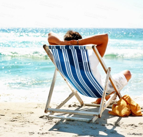 Человек в шезлонге на пляже