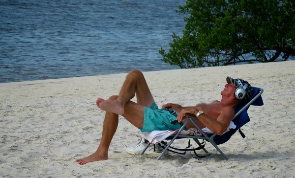 Мужчина на шезлонге с ногами