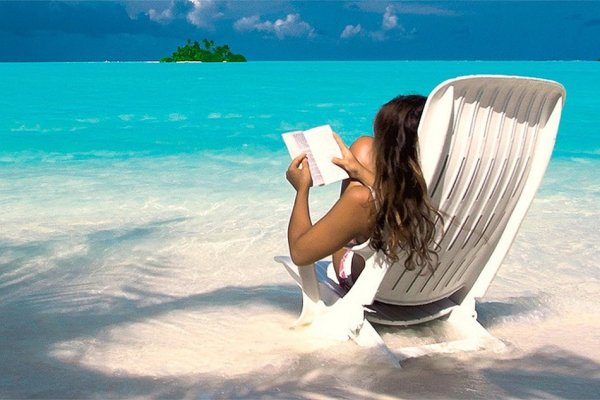 Девушка на пляже с книжкой